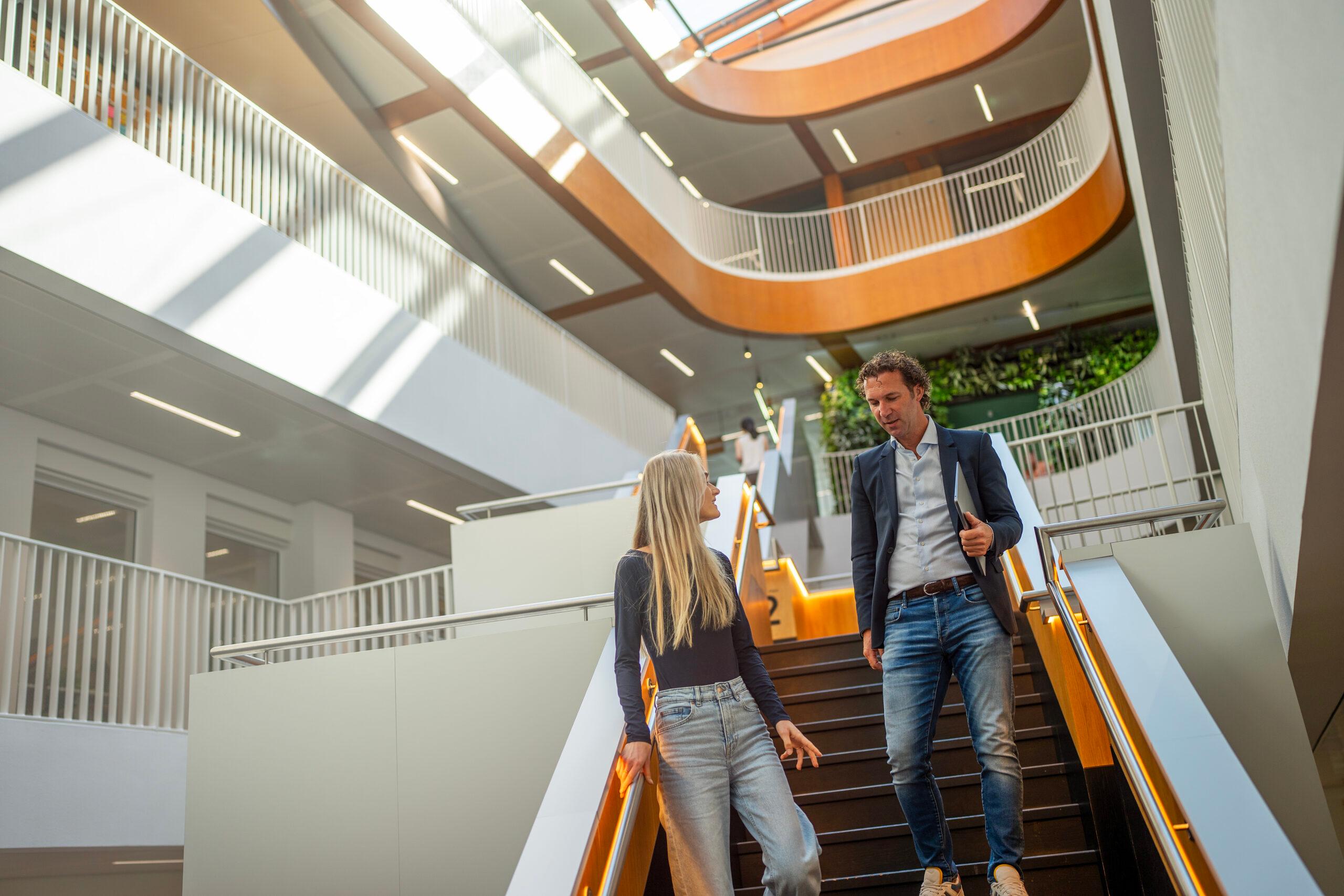 Een medewerker en een leidinggevende zitten tegenover elkaar aan een bureau in gesprek over het salaris onderstrepend het belang van open communicatie en vertrouwen in professionele relaties