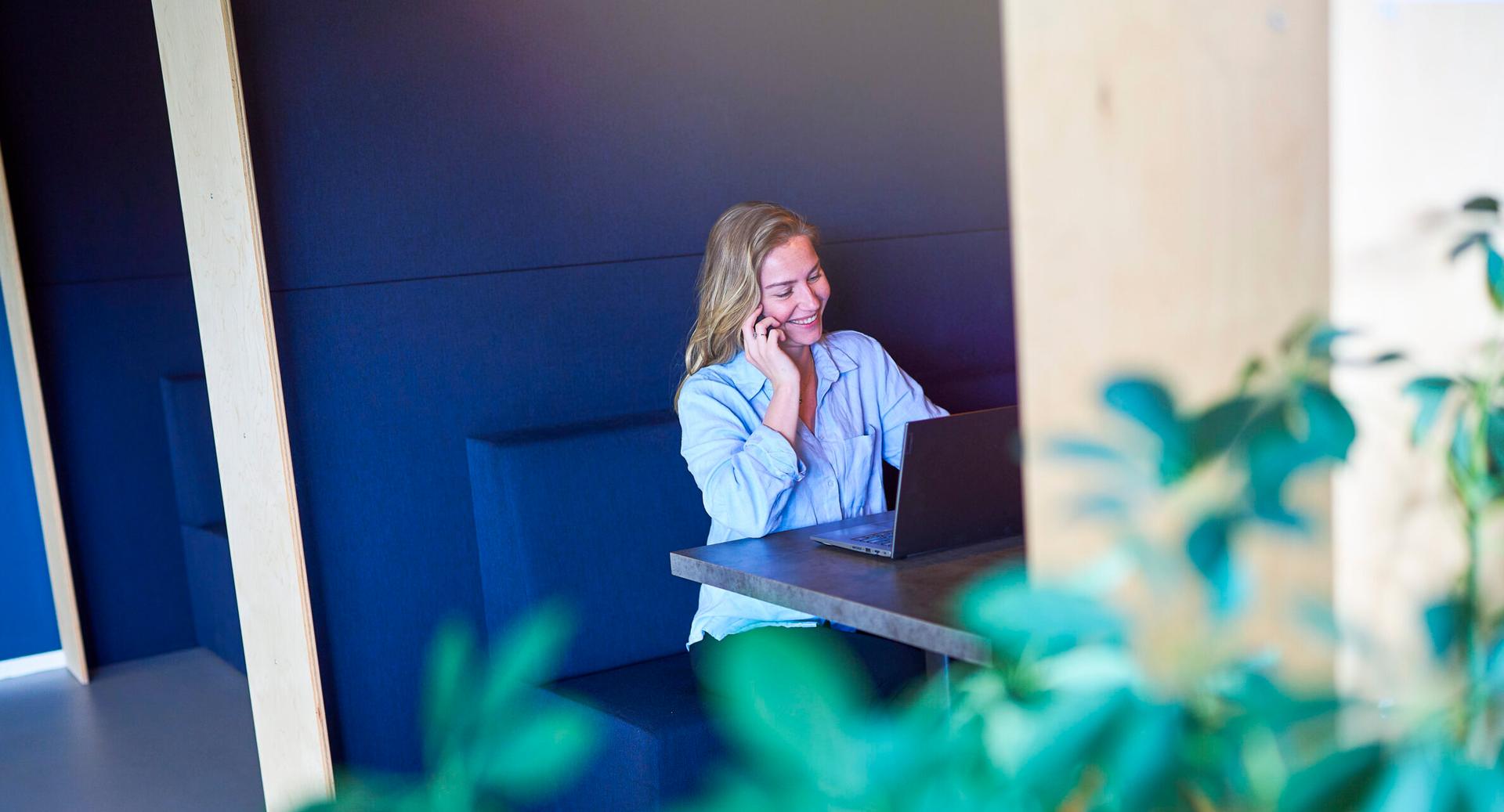 Telesales medewerker bij Budget Thuis is aan de telefoon, glimlachend.
